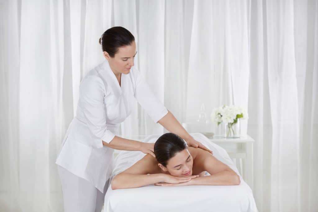 A woman receiving a massage by professional masseuse