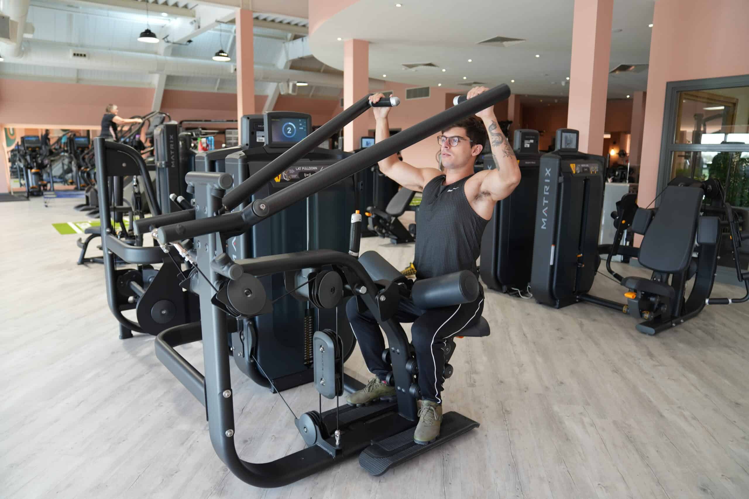 Gym member on lat pull-down machine
